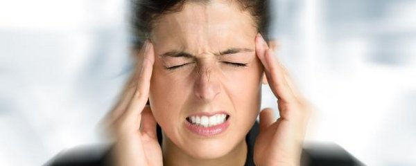 Frau mit Kopfschmerzen im Büro