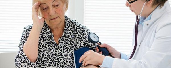 Frau beim Arzt zur Blutdruckmessung