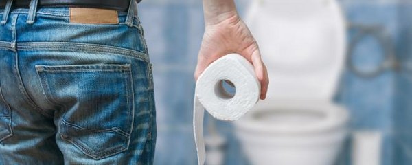 mann mit Toilettenpapier im Badezimmer