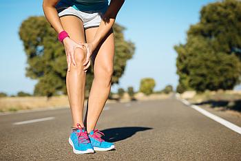 Knirschen im Knie Jogger fasst sich ans Kniegelenk